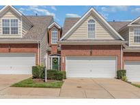 Charming brick townhome with an attached garage and a well-manicured lawn in a residential neighborhood at 8004 Thrush Ridge Ln, Raleigh, NC 27615
