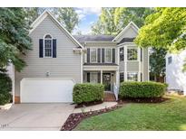 Charming gray two-story home boasts a manicured lawn, attached garage, and inviting front porch at 9504 Anson Grove Lane Ln, Raleigh, NC 27615