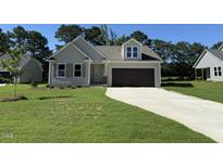 Charming single-Gathering home featuring a two-car garage, well-manicured lawn, and neutral color palette at 154 Oakfield Trace Dr, Four Oaks, NC 27524