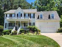 Charming two-story home featuring a welcoming front porch and beautifully landscaped yard at 18 Clover Hil Pl, Durham, NC 27712