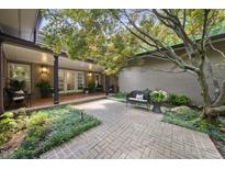Inviting courtyard with brick paving, lush greenery, and a cozy bench, perfect for outdoor relaxation and enjoying the serene surroundings at 213 Chimeneas Pl, Chapel Hill, NC 27517