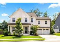 Charming two-story home with a manicured lawn, a covered front porch, and an attached two-car garage at 2713 Jazzy St, New Hill, NC 27562