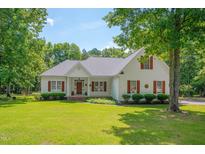 Charming white two-story home featuring a well-manicured lawn, mature trees, and inviting curb appeal at 300 Williamston Ridge Dr, Youngsville, NC 27596