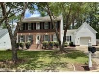Charming two-story brick home featuring black shutters, a manicured lawn, and mature trees for added curb appeal at 3045 Creek Moss Ave, Wake Forest, NC 27587
