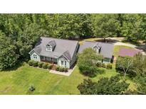 Charming two-story home featuring a bay window, dormers, and lush, mature landscaping at 3113 Golden Nugget Dr, Clayton, NC 27520