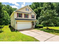 Charming two-story home with a two-car garage, red shutters, and a well-manicured lawn at 3445 Dutchman Rd, Raleigh, NC 27610