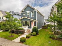 Charming two-story home with a well-manicured lawn, landscaped bushes and a welcoming red front door at 426 Granite Mill Blvd, Chapel Hill, NC 27516