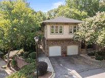 Charming home featuring a stone base, two-car garage, and beautiful landscaping at 4511 Crab Creek Dr # 101, Raleigh, NC 27612