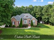 Beautiful brick home with manicured lawn, mature trees, and charming curb appeal at 517 Belmont Cir, Wake Forest, NC 27587