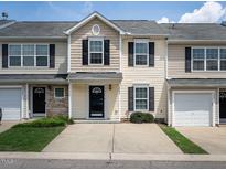 Charming townhome featuring a well-manicured lawn, black shutters, and a gray roof at 5225 Big Bass Dr, Raleigh, NC 27610