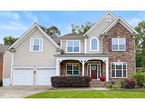 Charming two-story home with stone accents, a well-manicured lawn, and a two-car garage at 534 Siltstone Pl, Cary, NC 27519