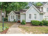 Charming home with light blue siding, a well-manicured lawn, and a welcoming walkway to the front door at 6213 Fountainhead Dr, Raleigh, NC 27609