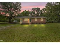 Charming brick home featuring a spacious front yard, complemented by mature trees and a welcoming facade at 658 Love Grove Church Rd, Sanford, NC 27332