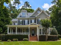 Charming two-story home with a covered front porch and manicured landscaping at 709 Skymont Dr, Holly Springs, NC 27540