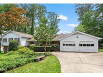 Charming home with a well-manicured lawn, a two-car garage, and mature trees at 7620 Harps Mill Rd, Raleigh, NC 27615