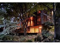 Charming exterior view of home with wood accents and lush landscaping at night at 820 Runnymede Rd Rd, Raleigh, NC 27607