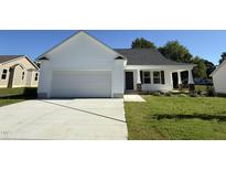 Charming single-story home with a two-car garage, inviting front porch, and well-maintained lawn at 91 Oakfield Trace Dr, Four Oaks, NC 27524