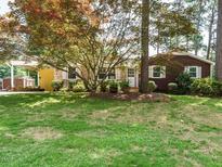 Charming single-story home featuring a well-maintained lawn, mature trees, and a welcoming facade at 100 Upton Ct, Garner, NC 27529