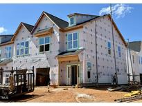 New construction home with protective wrap, featuring modern architectural details and ample window space at 107 Ripple Way # 209, Clayton, NC 27520