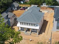 New two-story home with a gray roof, white siding, and a welcoming front porch with stone accents at 1225 Dixie Trl, Raleigh, NC 27607