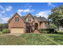 Charming two-story brick home with manicured lawn, arched entry, and attached two-car garage at 12412 Mayhurst Pl, Raleigh, NC 27614