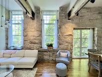 Bright living room featuring stone walls, hardwood floors, beamed ceilings, and lots of natural light from large windows at 1500 River Mill Dr # 310, Wake Forest, NC 27587