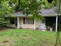 Charming bungalow-style home with a covered front porch, lush greenery, and a serene setting at 1806 Rendall St, Burlington, NC 27215