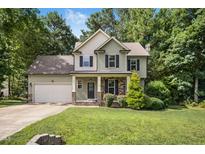 Charming two-story home with a manicured lawn, attached garage, and a mix of stone and siding accents at 210 Water Oak Way, Louisburg, NC 27549