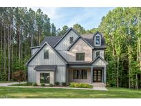 Beautiful gray two-story home featuring a stone facade and manicured lawn at 2124 Country Air Ln, Hillsborough, NC 27278