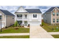 Charming two-story home featuring a double front porch and a well-maintained lawn at 222 Oak Branch - Lot 72 Trl, Garner, NC 27529