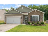Charming single-story home featuring stone and tan siding with a well-manicured front lawn at 2730 Spring Valley Dr, Creedmoor, NC 27522