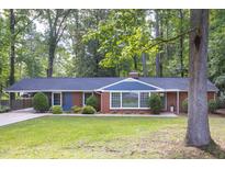 Charming single-story brick home with lush green lawn, landscaping, and inviting curb appeal at 2801 E Shoreham St, Durham, NC 27707