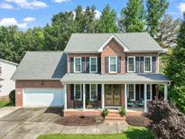 Charming brick two-story home with a welcoming front porch and manicured landscaping at 2925 Dargan Hills Dr, Wake Forest, NC 27587