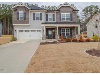 Charming two-story home with manicured lawn, two-car garage and inviting front porch at 301 Porter Hill Dr, Youngsville, NC 27596