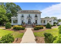 Stately two-story home with a symmetrical facade, multiple balconies and a well-manicured front lawn at 309 W Divine St, Dunn, NC 28334