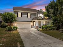 Charming two-story home featuring a well-manicured lawn, covered porch, and attached two-car garage at 317 Striped Maple Ct, Apex, NC 27539