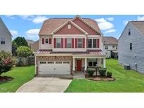 Charming two-story home featuring a stone facade, red shutters and a well-manicured lawn at 40 Horizon Trl, Garner, NC 27529