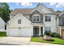 Charming two-story home featuring a stone facade, two-car garage, and manicured front lawn at 5421 Brandy Bay Rd, Raleigh, NC 27613