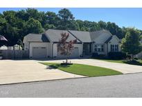 Charming single-story home boasts an attached two-car garage and a well-manicured front lawn, complete with tasteful landscaping at 85 Willard Wood Run, Benson, NC 27504