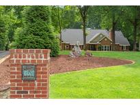 Charming brick home with landscaped front yard and mature trees at 9940 Koupela Dr, Raleigh, NC 27614