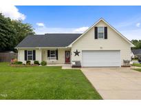 Charming one-story home with a well-maintained lawn and a cozy front porch sitting area at 10 Oxford Dr, Angier, NC 27501