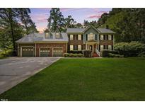 Charming two-story brick home with a three-car garage and landscaped front yard at 1005 Enderbury Dr, Raleigh, NC 27614