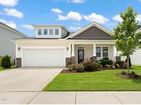 Charming home featuring manicured lawn, gray stone accents and a two-car garage at 1109 Briar Gate Dr, Holly Springs, NC 27540