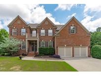 Charming two-story brick home with a well-manicured lawn, two-car garage, and classic architectural details at 111 Revere Forest Ct, Cary, NC 27519