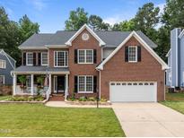 Charming brick home featuring a manicured lawn and an attached two-car garage at 114 Council Gap Ct, Cary, NC 27513