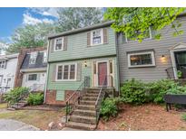 Charming two-story home featuring a red front door and quaint front yard with inviting steps at 1302 Springlawn Ct, Raleigh, NC 27609