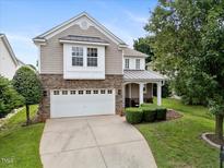Charming home featuring a stone facade, two-car garage, and well-maintained landscaping at 132 Ryder Cup Cir, Raleigh, NC 27603