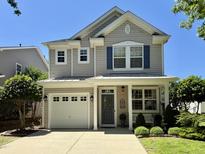 Charming two-story home featuring a well-manicured front yard, attached garage, and inviting front porch at 137 Palmdale Ct, Holly Springs, NC 27540