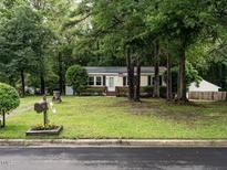 Charming single-story home with a lush front lawn and mature trees, creating a welcoming curb appeal at 203 Lane Of Sir Kay, Garner, NC 27529