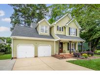 Charming two-story home with a two-car garage, covered porch and manicured landscaping at 2218 Watersglen Dr, Apex, NC 27502